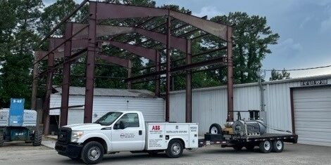 An exterior photograph of Rocky Mount Electric Motor with one of their trucks pulling an electric motor on a trailer.