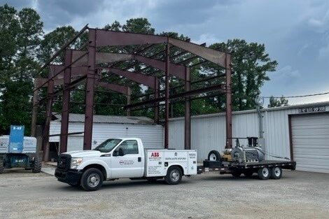 An exterior photograph of Rocky Mount Electric Motor with one of their trucks pulling an electric motor on a trailer.
