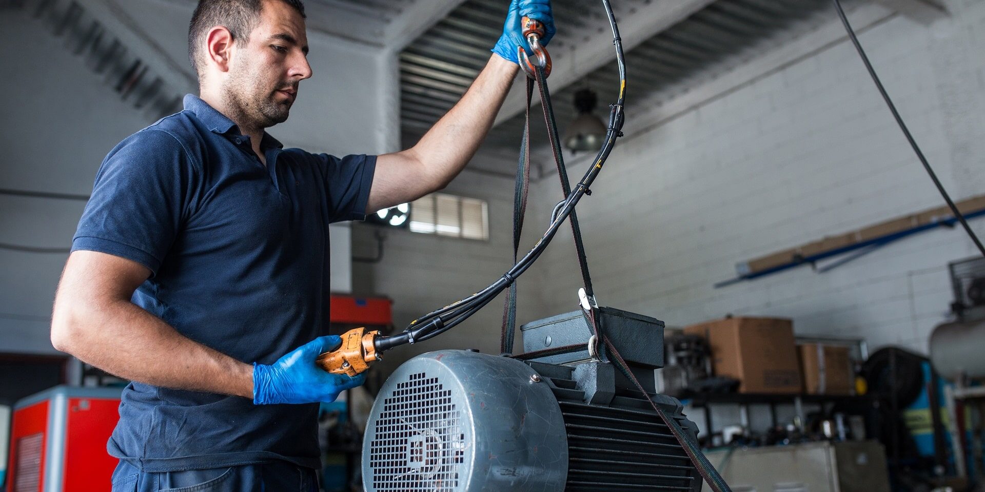mechanic-preparing-engine-electric-motor-vibration-analysis A mechanic moves an electric motor to prepare it for vibration analysis.