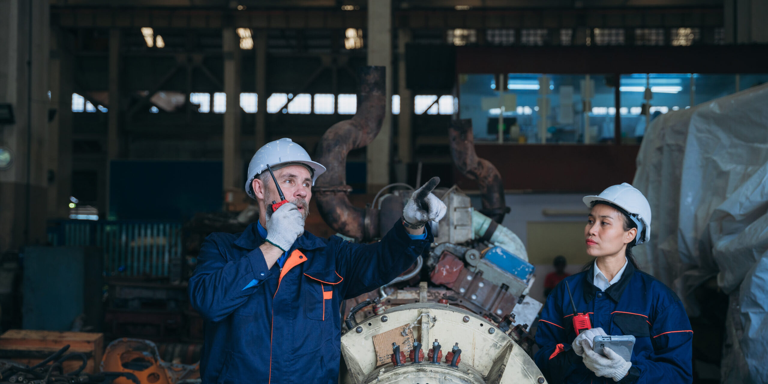 Team engineers are on duty and talking, looking at, and repairing the big machine in the railroad garage. Team engineers are on duty and talking, looking at, and repairing the big machine in the garage.